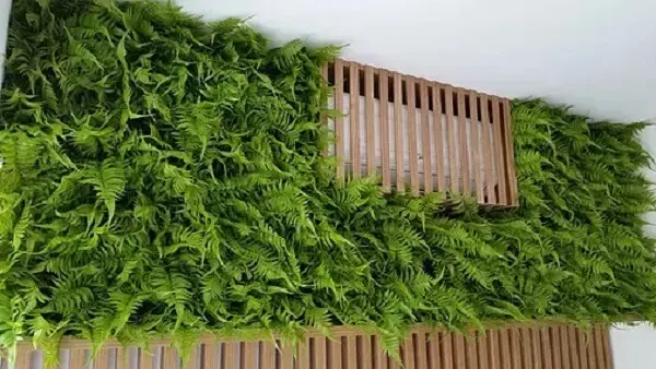 50. Jardim vertical artificial feito com samambaias esconde ar condicionado. Fonte: Pinterest